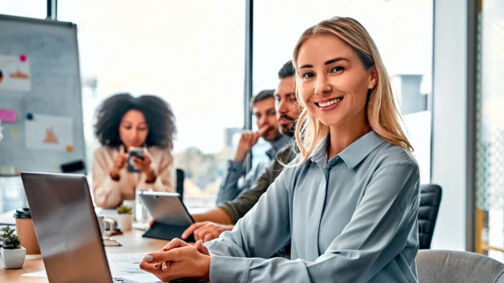 Women simling infornt of the computer with her team