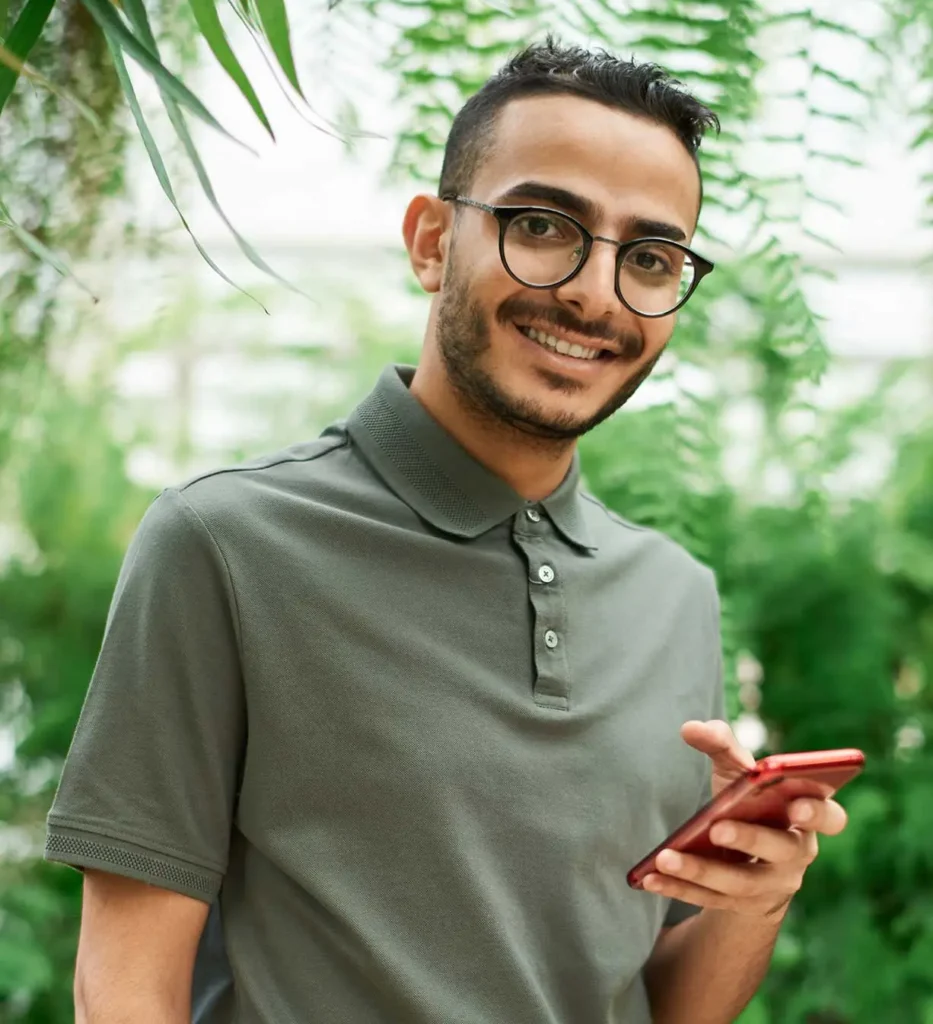 A man smiling whiling holding phone